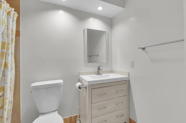 a bathroom with a toilet sink and mirror