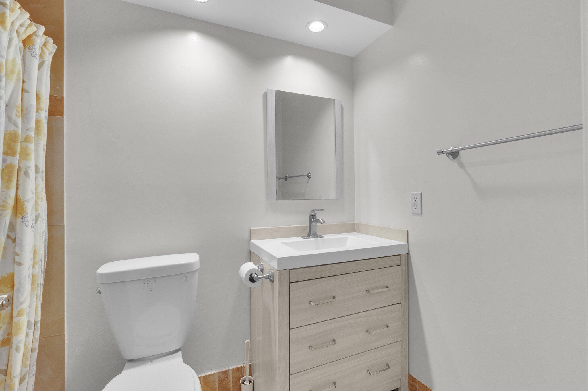 392 Monaco Way, Unit 392 Delray Beach, FL 33446 - Photo 22 of 47 a bathroom with a toilet sink and mirror