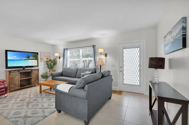 a living room with furniture a flat screen tv and a window