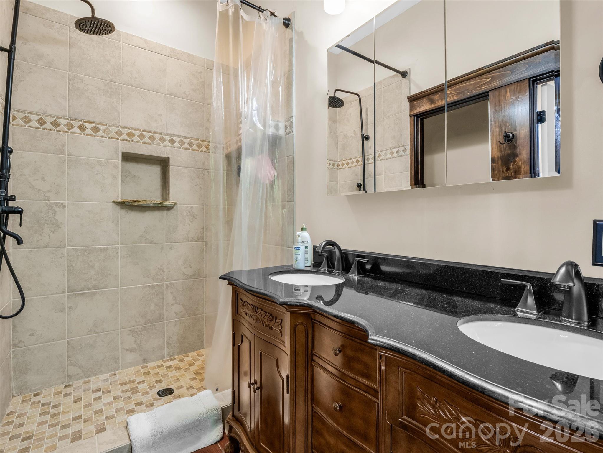 174 Rock Ridge Lake Lure, NC 28746 - Photo 18 of 48 a bathroom with a granite countertop sink a mirror and shower