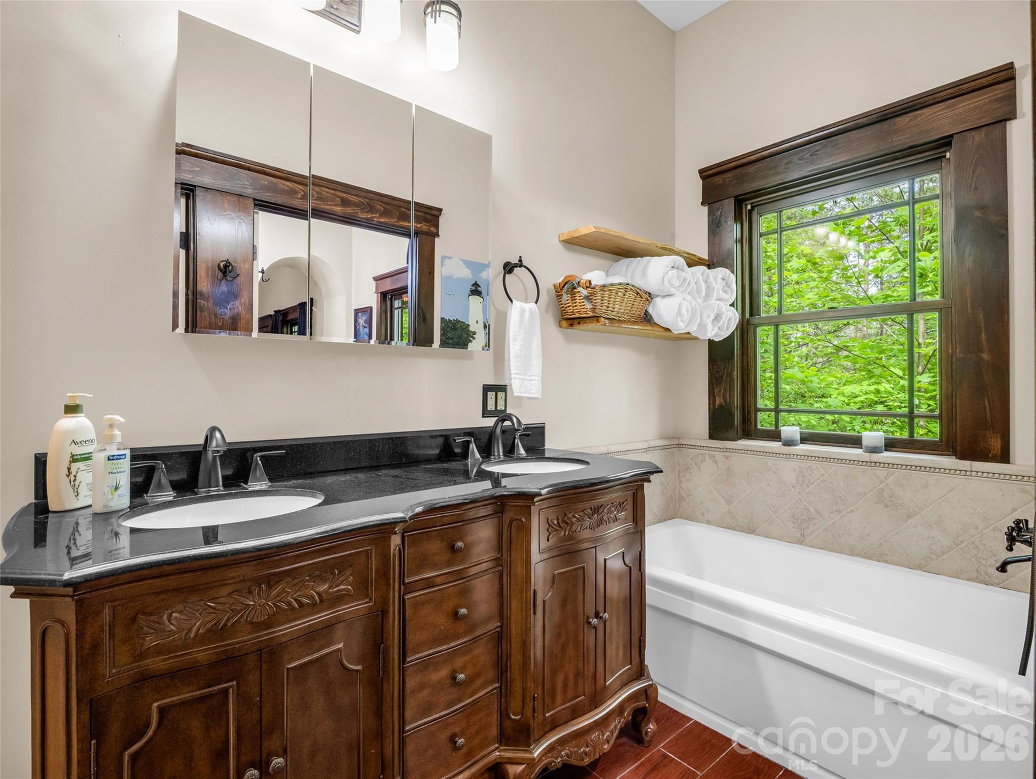 174 Rock Ridge Lake Lure, NC 28746 - Photo 19 of 48 a bathroom with a granite countertop sink mirror and a bathtub