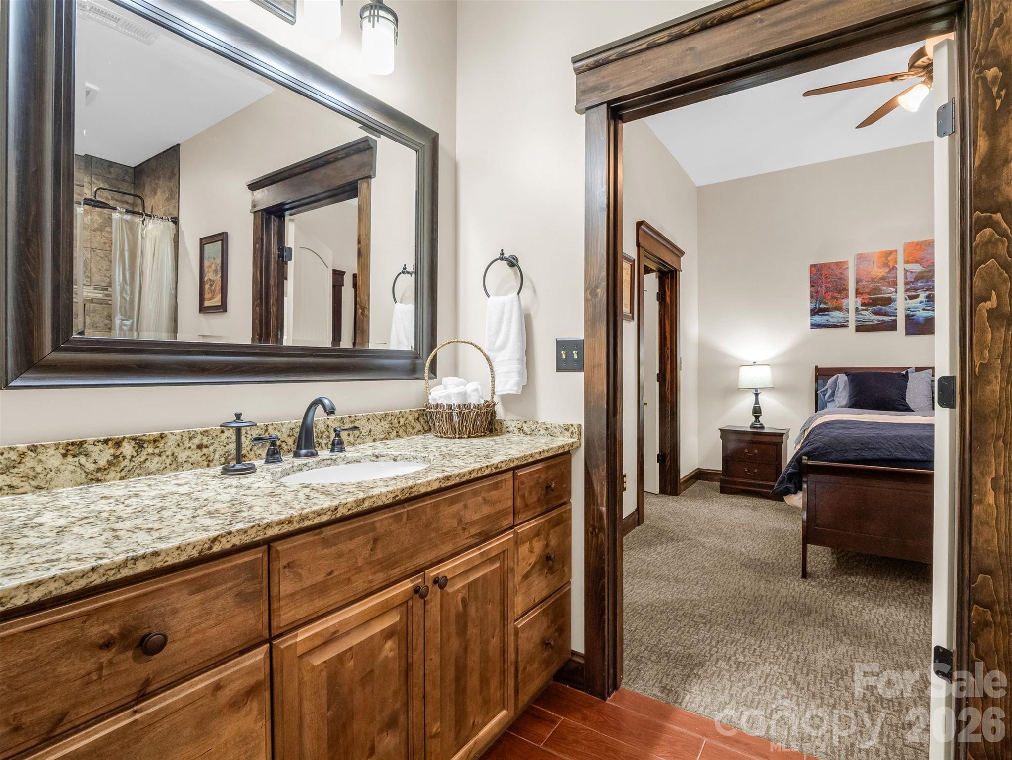 174 Rock Ridge Lake Lure, NC 28746 - Photo 34 of 48 a en suite bathroom with a granite countertop sink and a mirror