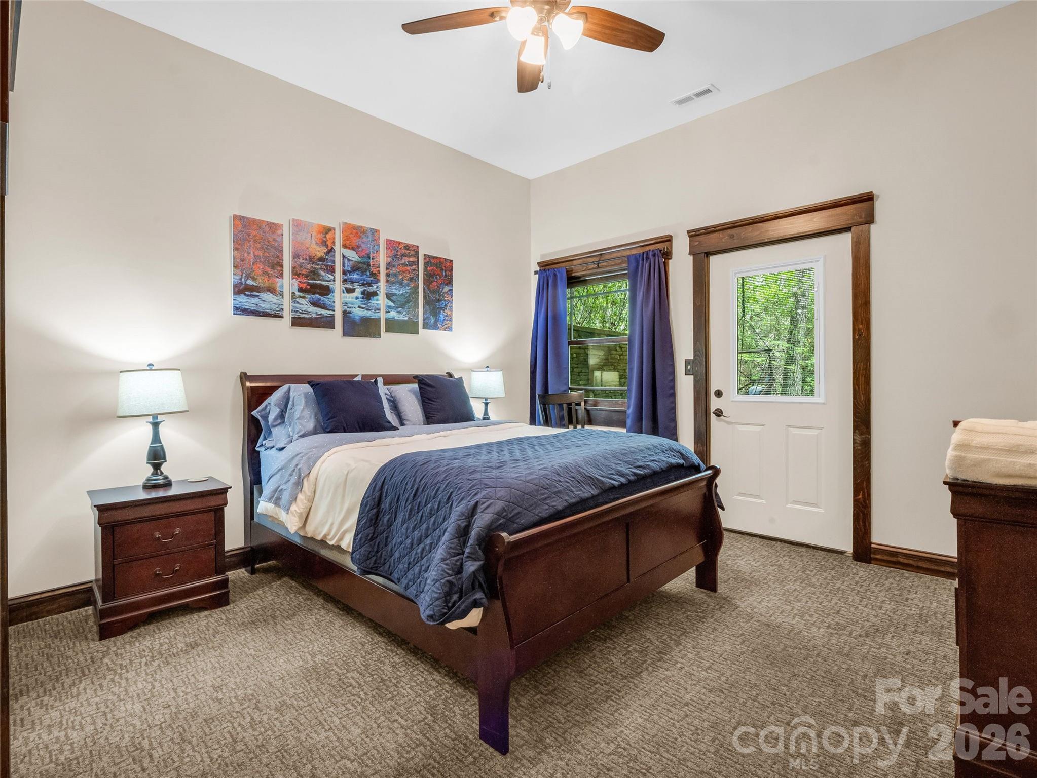 174 Rock Ridge Lake Lure, NC 28746 - Photo 35 of 48 a spacious bedroom with a bed and a chandelier