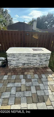 a view of a backyard with a barbeque and wooden fence