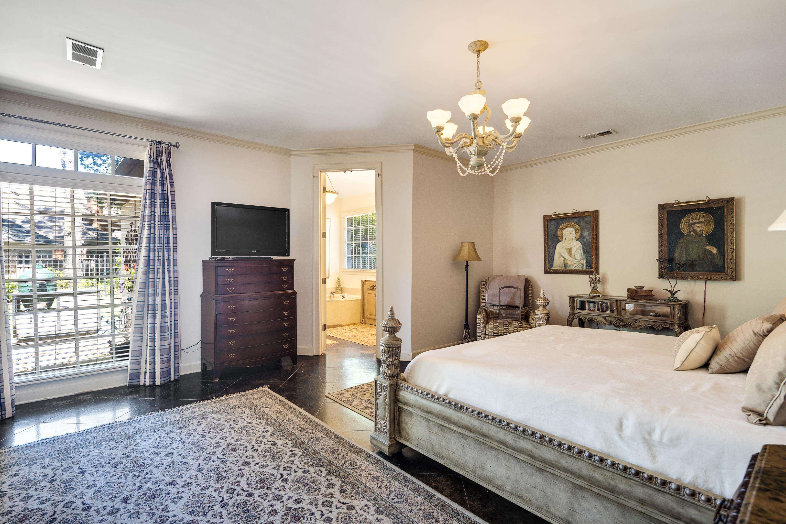 210 Ivy Grove Lane Collierville, TN 38017 - Photo 20 of 40 a spacious bedroom with a bed and a chandelier