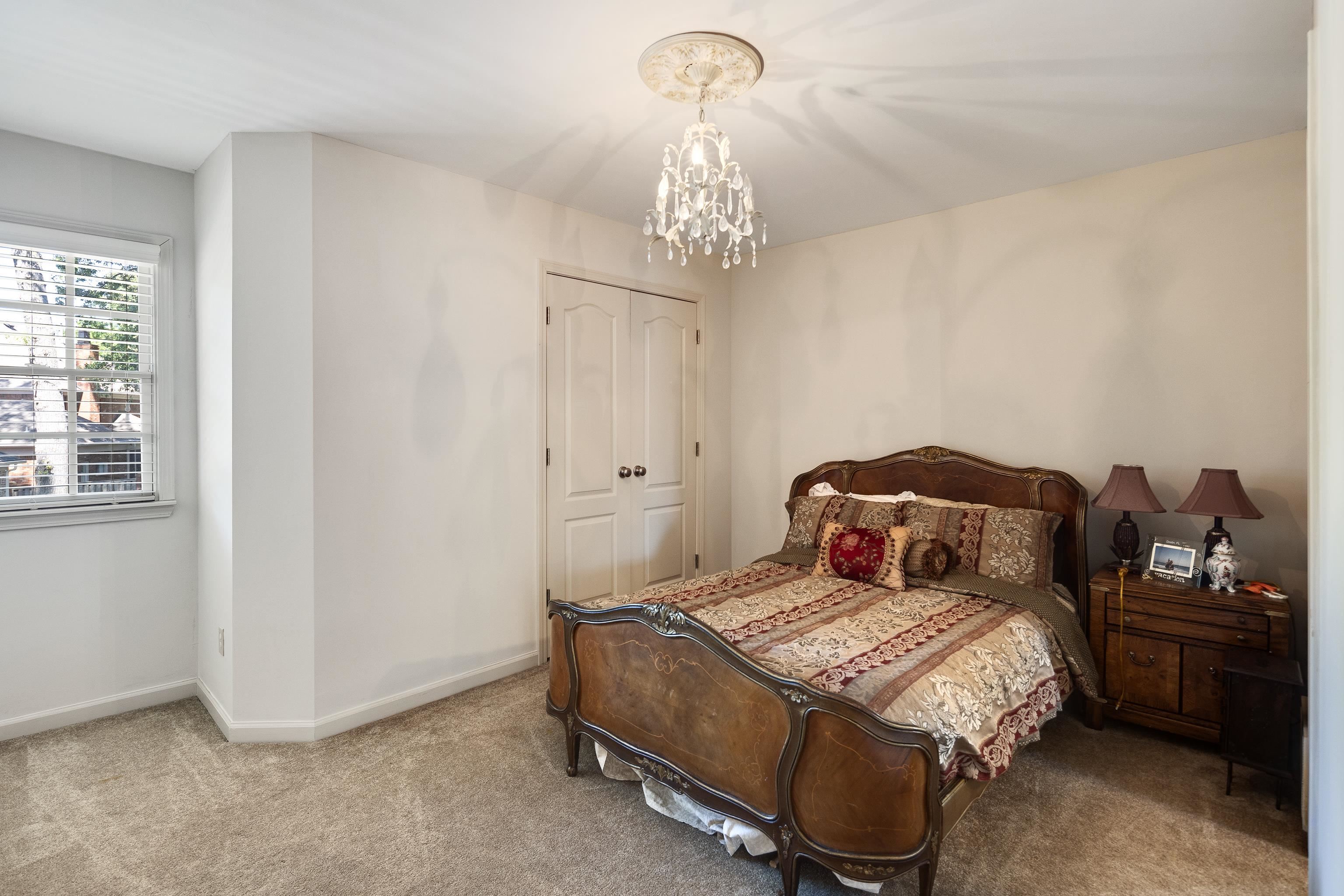 210 Ivy Grove Lane Collierville, TN 38017 - Photo 25 of 40 a bedroom with a bed and a chandelier