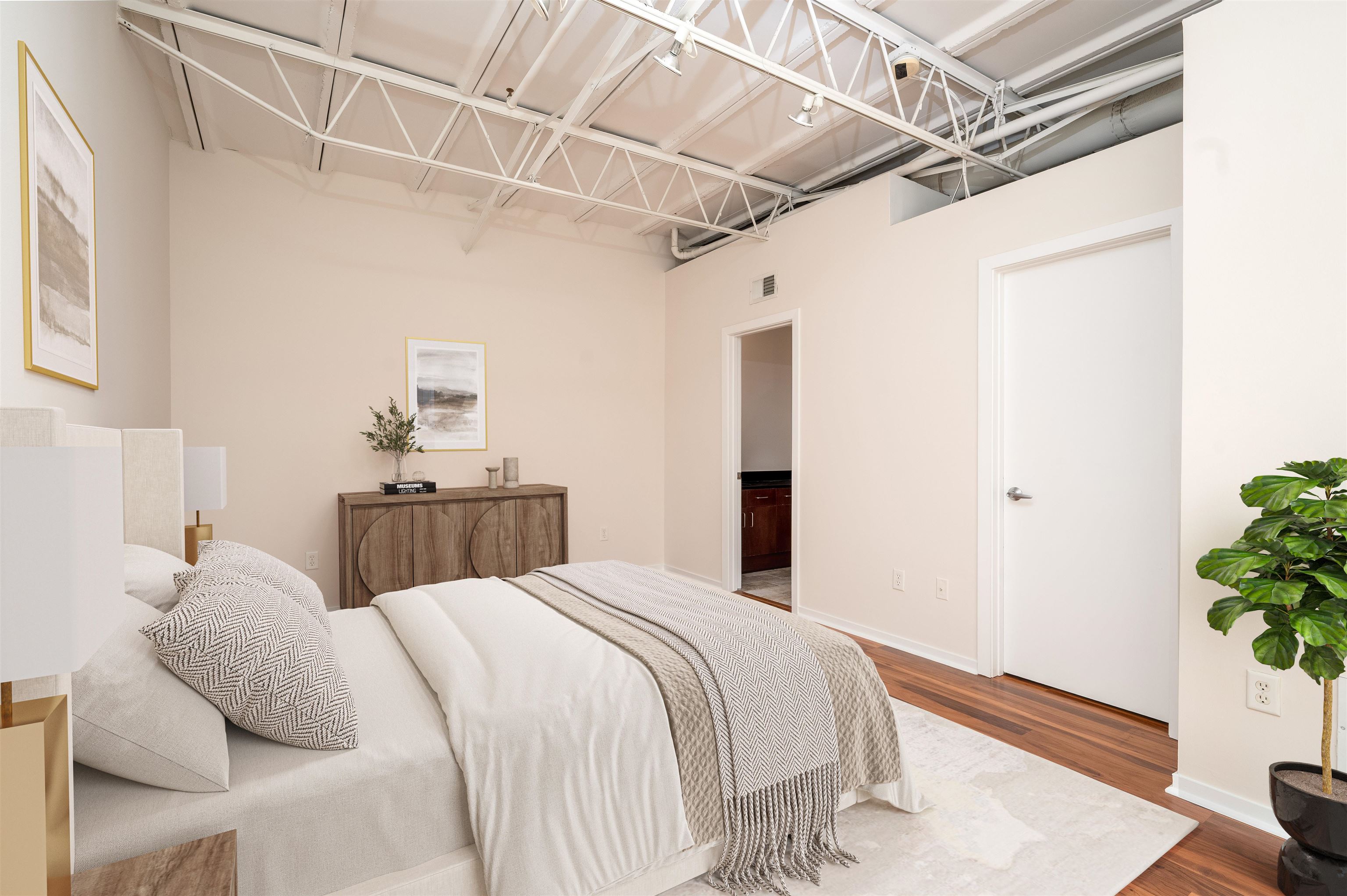 415 South Front Street, Unit 114 Memphis, TN 38103 - Photo 13 of 26 a bedroom with a bed and a potted plant