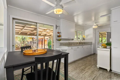 a kitchen with a table chairs sink and wooden floor