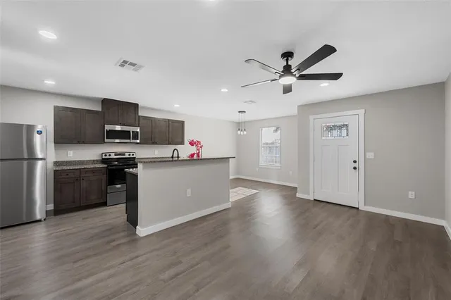 a kitchen with a refrigerator and a stove top oven
