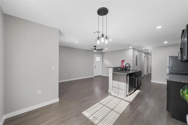 a view of a kitchen with a sink stainless steel appliances and a chandelier