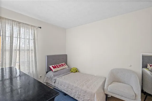 a bedroom with a bed and a couch with wooden floor