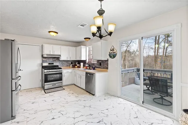 a kitchen with a refrigerator a stove top oven a sink and cabinets
