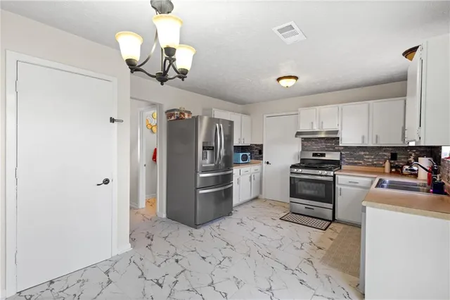 a kitchen with stainless steel appliances a refrigerator and a stove top oven
