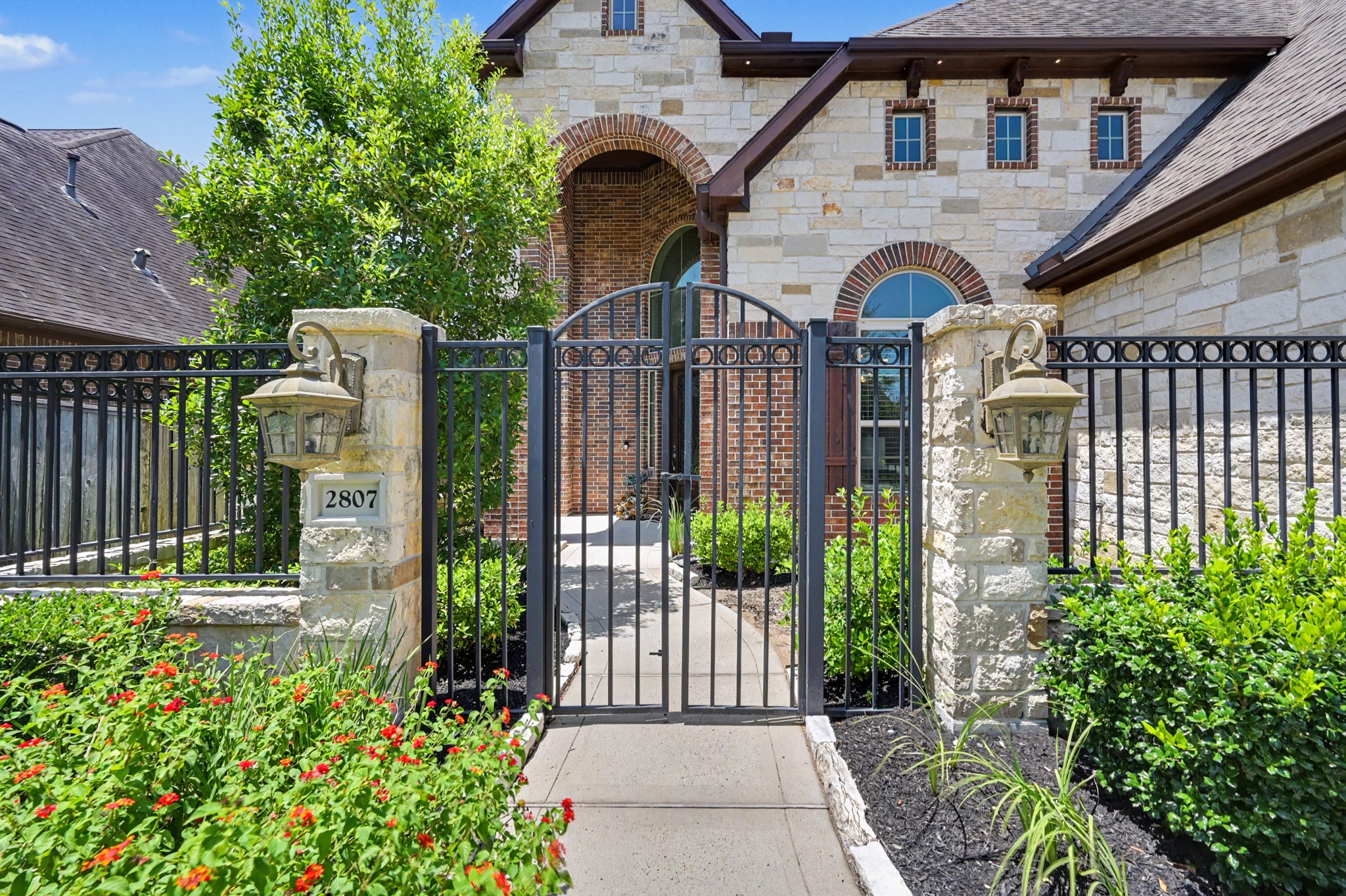 Stroll through the mature landscaping, wrought iron gate and private courtyard prior to entering the home.