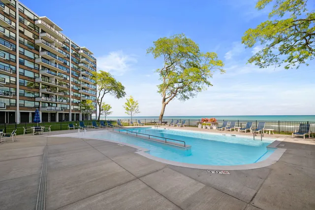 a view of a swimming pool with a lawn chairs under an umbrella