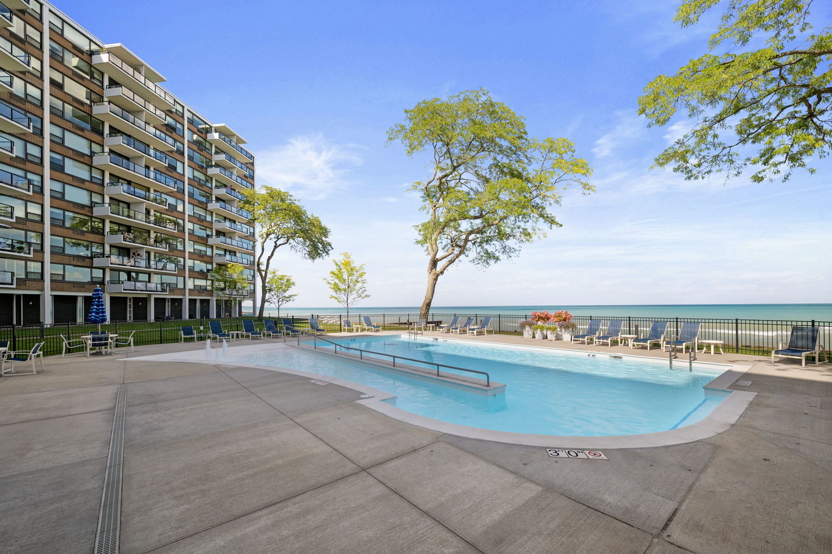1630 Sheridan Road, Unit 2F Wilmette, IL 60091 - Photo 21 of 25 a view of a swimming pool with a lawn chairs under an umbrella