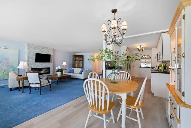 a dining room with furniture a chandelier and wooden floor