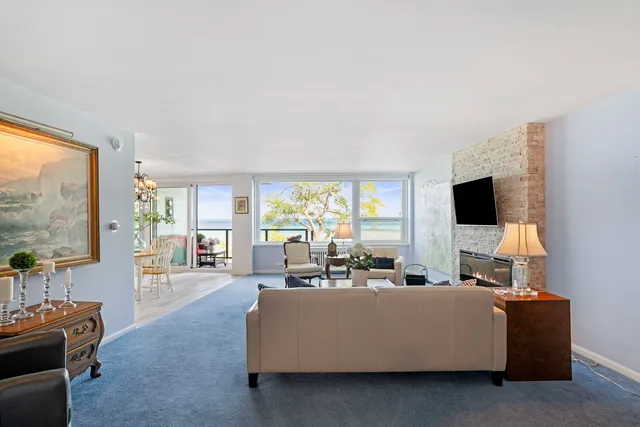 a living room with furniture a flat screen tv and a large window