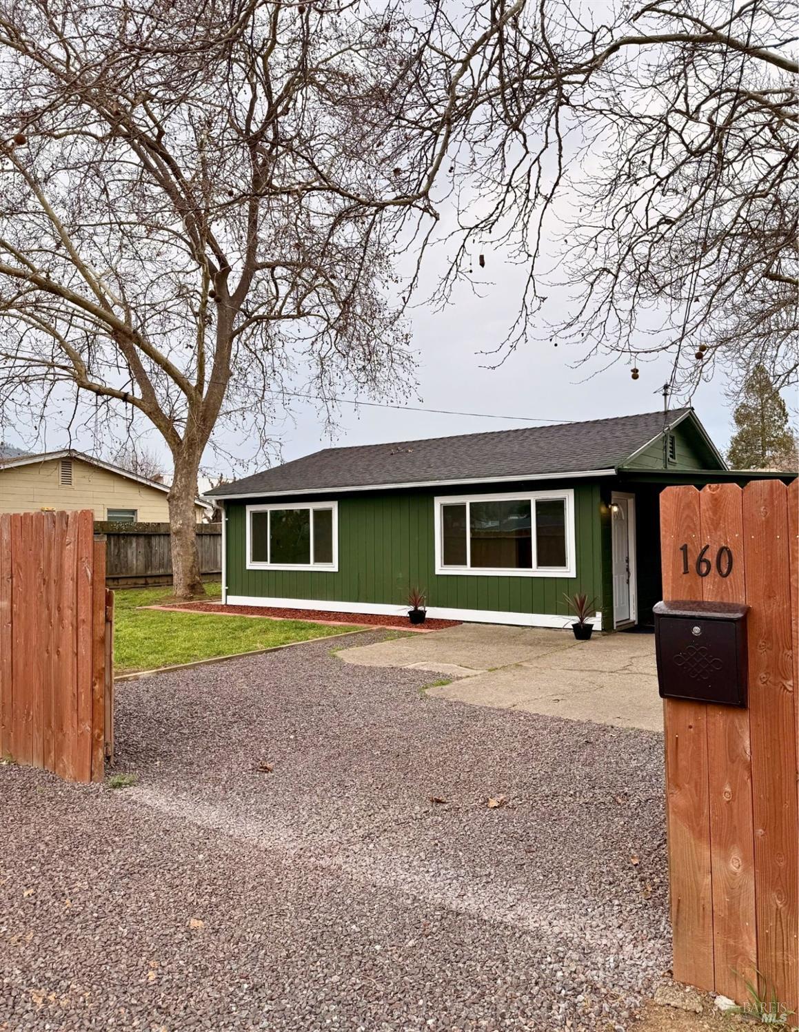 a front view of a house with a yard and parking space