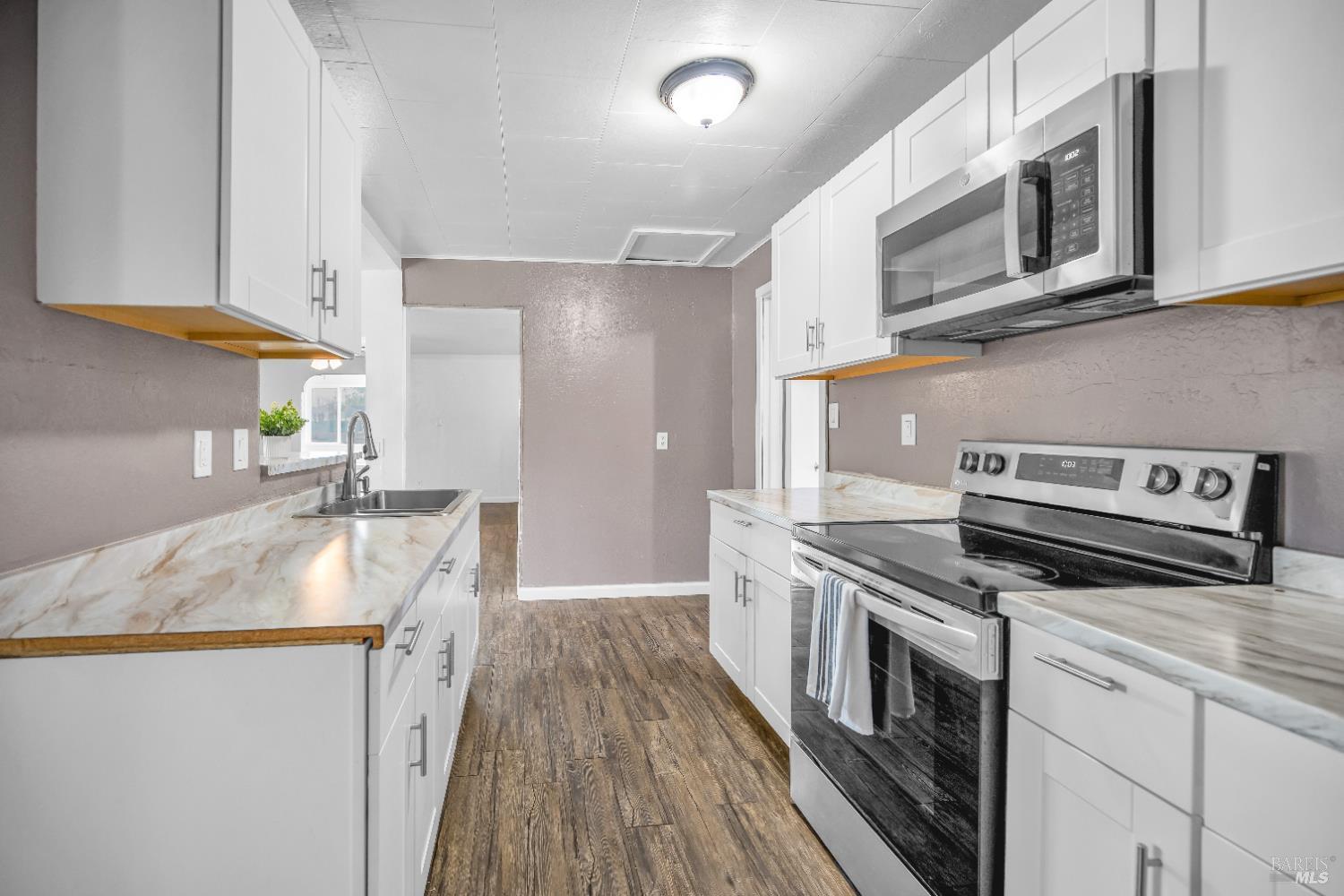 160 Thomas Street Ukiah, CA 95482 - Photo 9 of 26 a kitchen with granite countertop wooden cabinets and a stove top oven