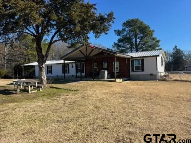 a view of a house with a yard and sitting area