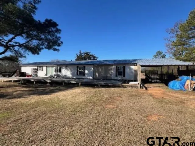 a front view of a house with a yard and a car