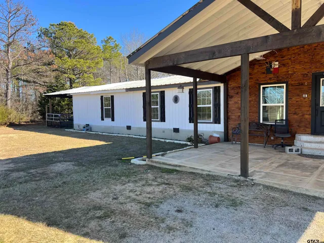 a view of a house with backyard and porch