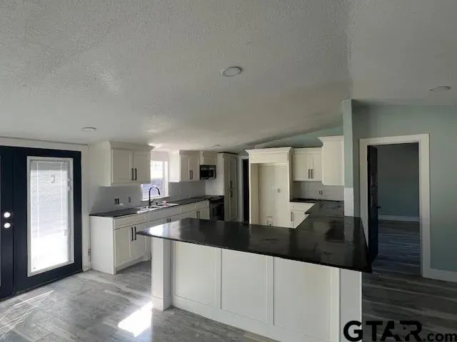 a kitchen with stainless steel appliances granite countertop a sink and cabinets