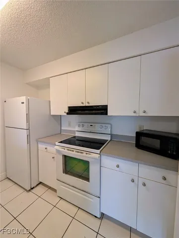 a kitchen with white cabinets and white appliances