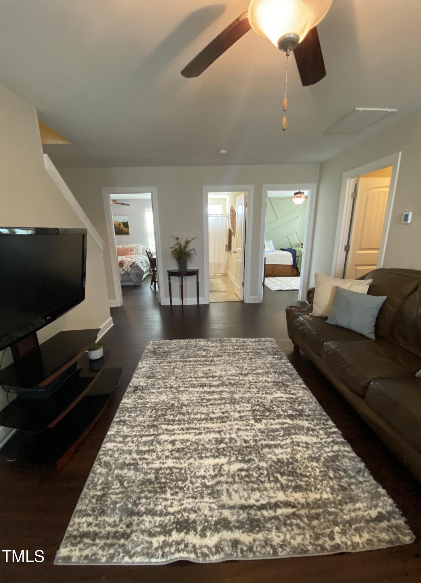 8305 Pin Cherry Drive Willow Spring, NC 27592 - Photo 29 of 60 a living room with a couch and a flat screen tv