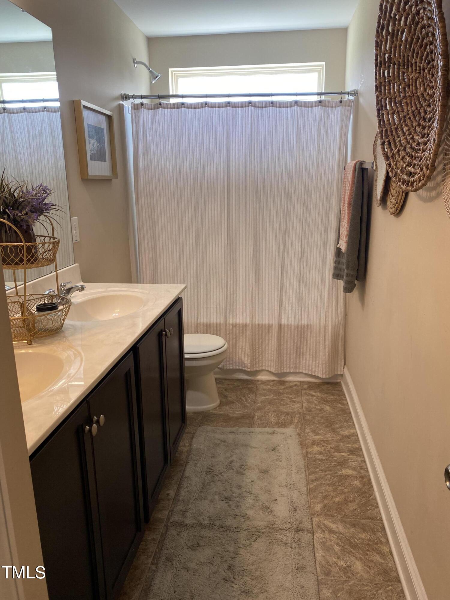 8305 Pin Cherry Drive Willow Spring, NC 27592 - Photo 30 of 60 a bathroom with a sink a toilet and a mirror