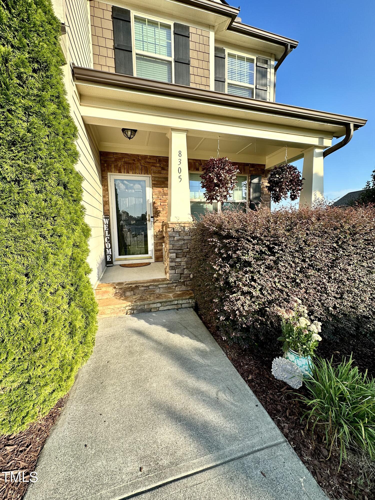 8305 Pin Cherry Drive Willow Spring, NC 27592 - Photo 3 of 60 a front view of a house with garden