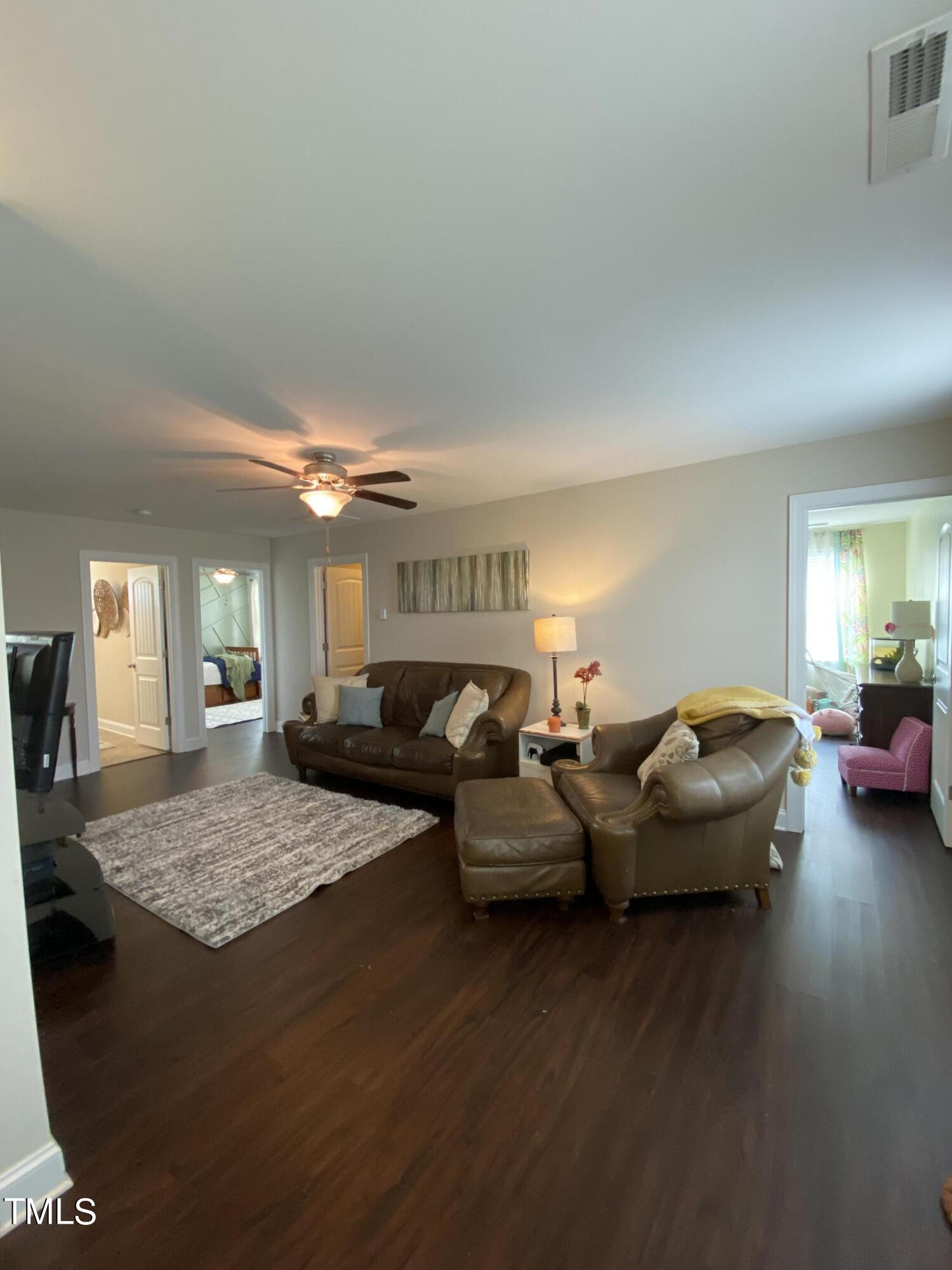 8305 Pin Cherry Drive Willow Spring, NC 27592 - Photo 32 of 60 a living room with couches and kitchen view