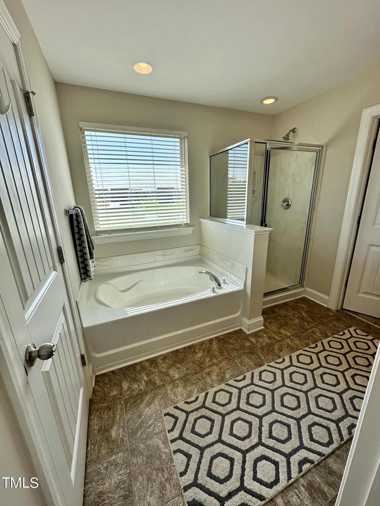 8305 Pin Cherry Drive Willow Spring, NC 27592 - Photo 43 of 60 a bathroom with a bathtub and shower