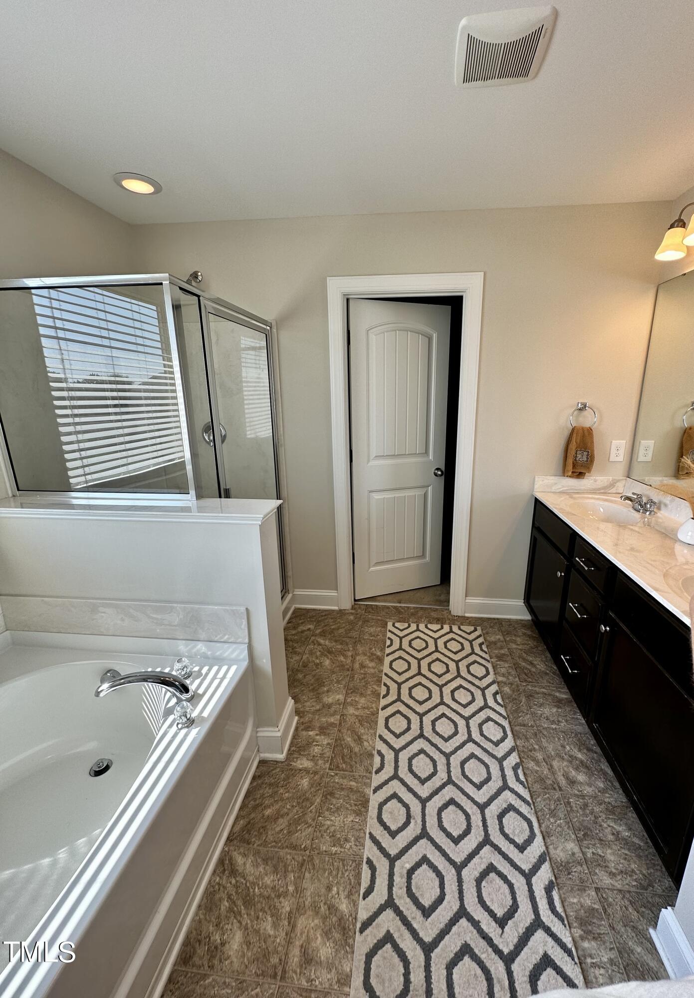 8305 Pin Cherry Drive Willow Spring, NC 27592 - Photo 44 of 60 a bathroom with a bathtub and a sink