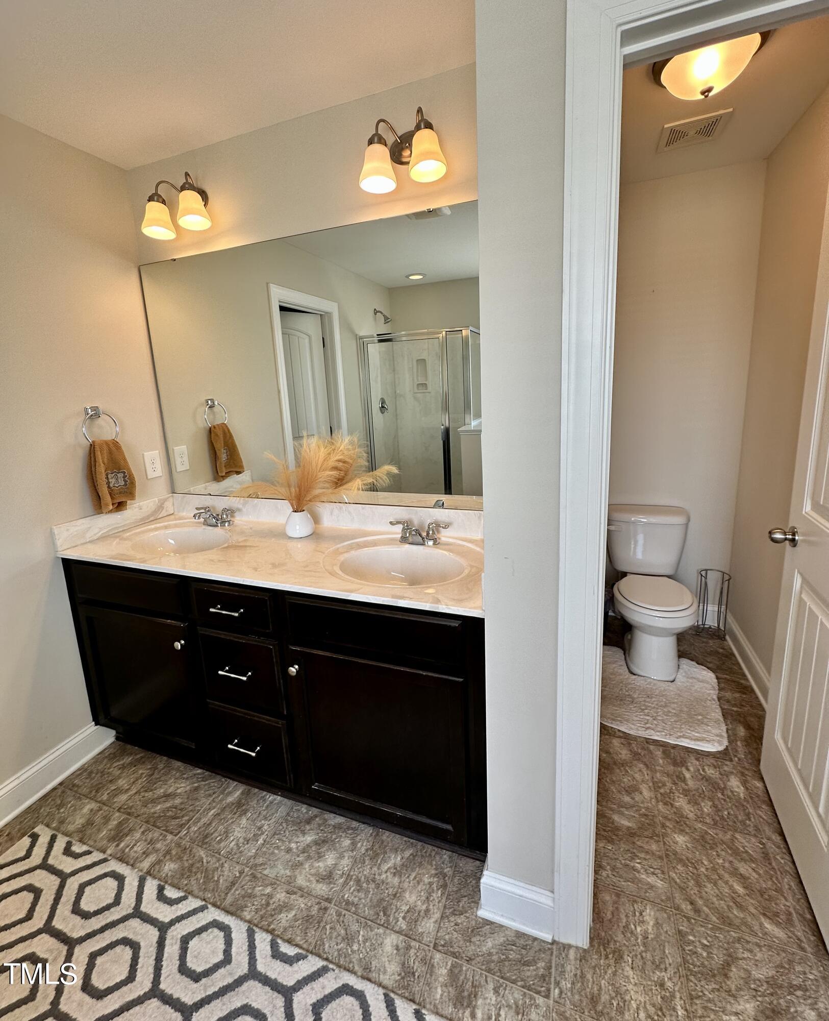 8305 Pin Cherry Drive Willow Spring, NC 27592 - Photo 45 of 60 a bathroom with a sink vanity and a mirror