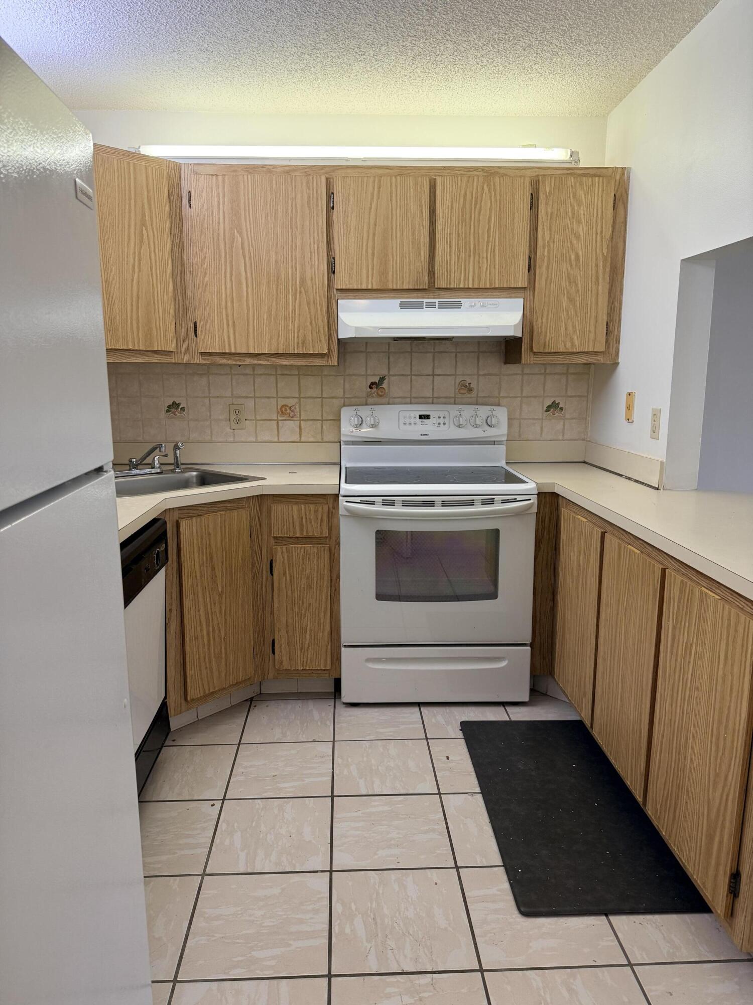 520 Shady Pine Way, Unit C2 Greenacres, FL 33415 - Photo 3 of 10 a kitchen with a stove top oven sink and cabinets