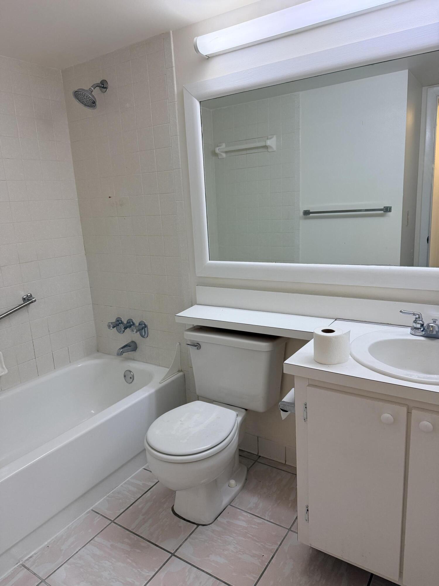 520 Shady Pine Way, Unit C2 Greenacres, FL 33415 - Photo 7 of 10 a white toilet sitting next to a bath tub