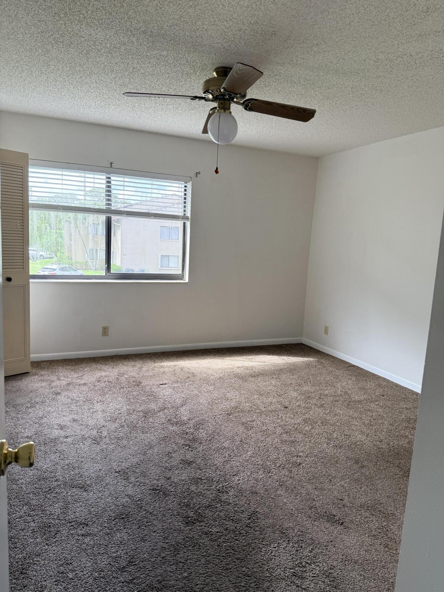 520 Shady Pine Way, Unit C2 Greenacres, FL 33415 - Photo 8 of 10 an empty room with a window and a ceiling fan