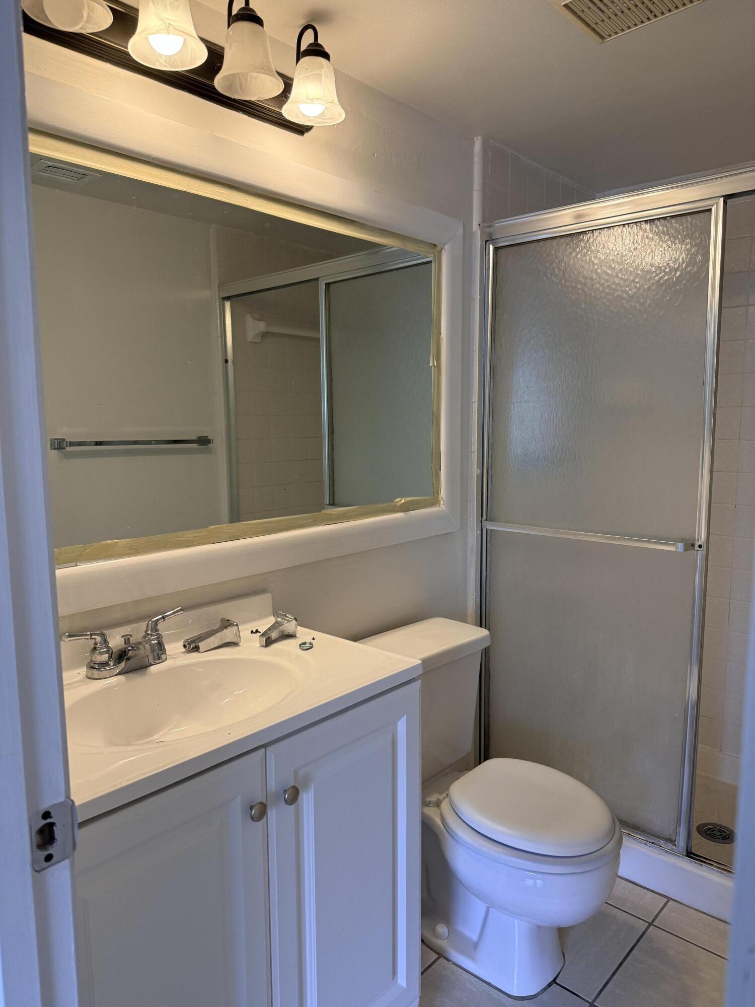 520 Shady Pine Way, Unit C2 Greenacres, FL 33415 - Photo 9 of 10 a bathroom with a sink toilet and mirror