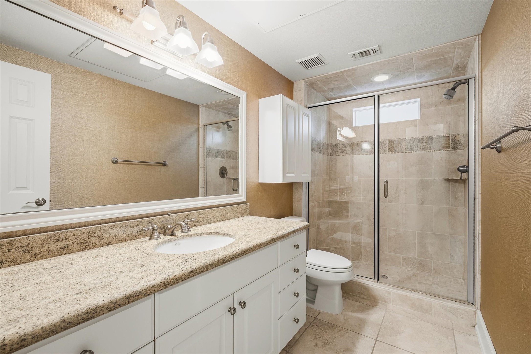 5507 Val Verde Street Houston, TX 77056 - Photo 13 of 42 a bathroom with a granite countertop sink a toilet a mirror and shower