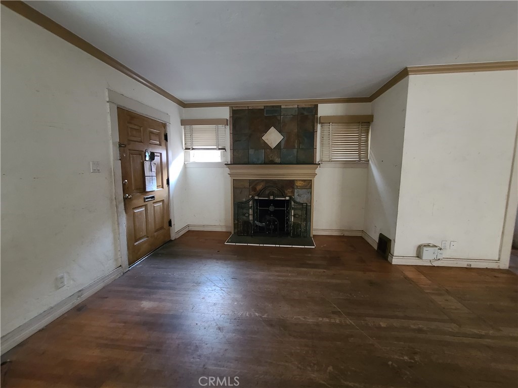 1148 Locust Avenue Long Beach, CA 90813 - Photo 4 of 22 an empty room with wooden floor fireplace and windows