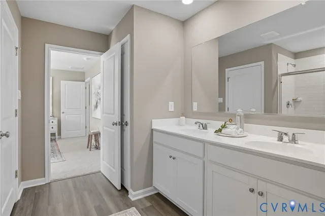 a en suite bathroom with a sink mirror and shower
