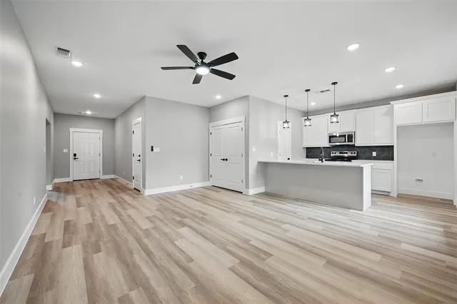 a view of an empty room with kitchen appliances and a window