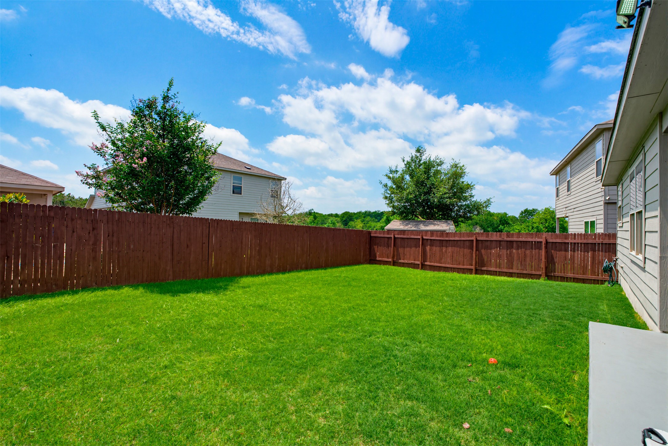 5705 Southerner Way Austin, TX 78747 - Photo 19 of 22 A well-maintained lawn stretches out in this private, fenced yard, offering ample space for outdoor enjoyment.
