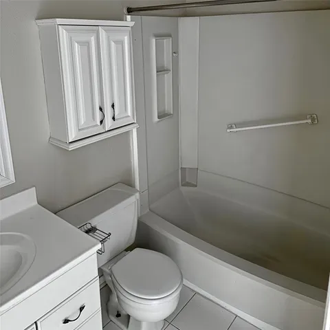 a white toilet sitting next to a bath tub