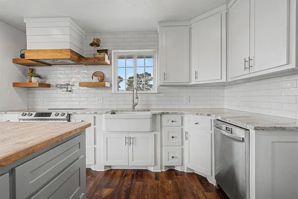 a kitchen with stainless steel appliances granite countertop a sink and cabinets