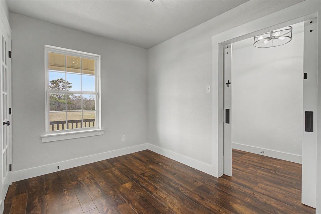 192 Riverside Drive Decatur, TX 76234 - Photo 15 of 32 a view of an empty room with wooden floor and a window