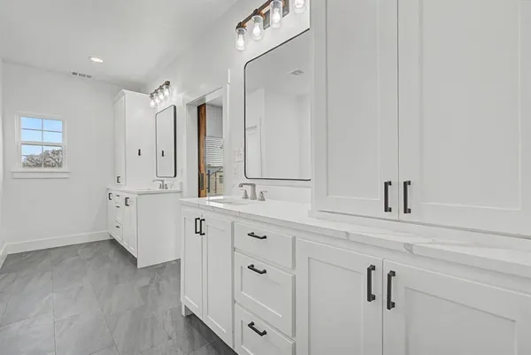 a spacious bathroom with double vanity sink a mirror and bathtub