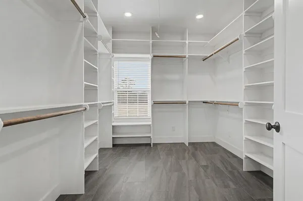 a view of walk in closet with empty racks